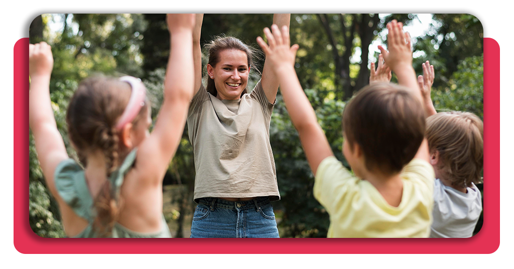 Monitores titulados guiando juegos lúdicos y dinámicas grupales con niños en un campamento de verano al aire libre en España, fomentando la inclusión activa