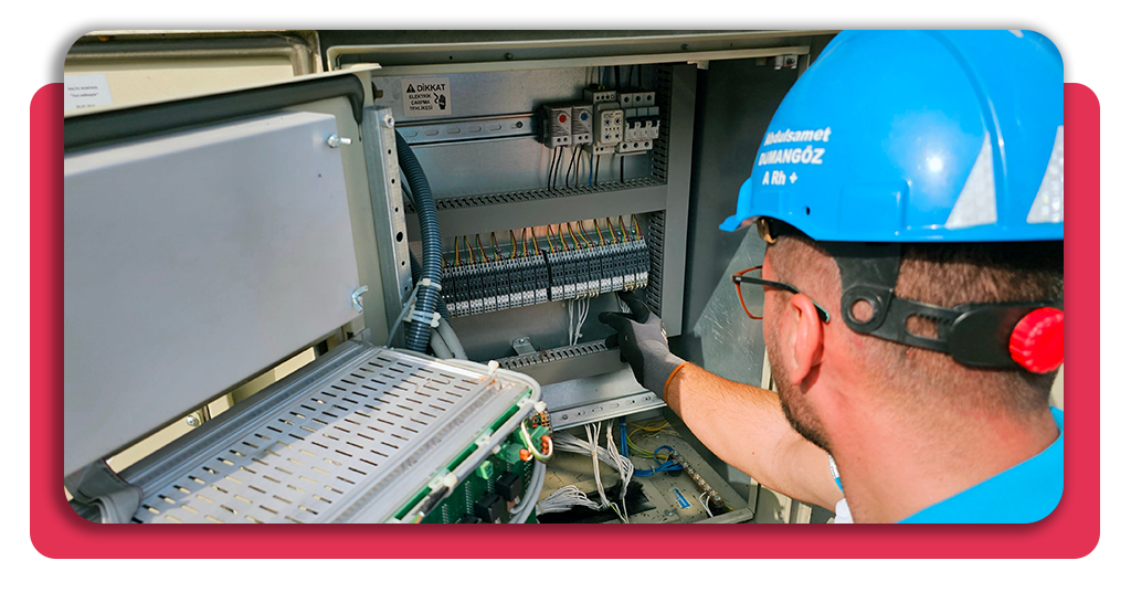 Curso gratis de automatización industrial: ¡inscríbete ya! 2 Hombre joven trabajando en el área de automatización industrial en una empresa. Lleva un casco azul de seguridad y guantes protectores