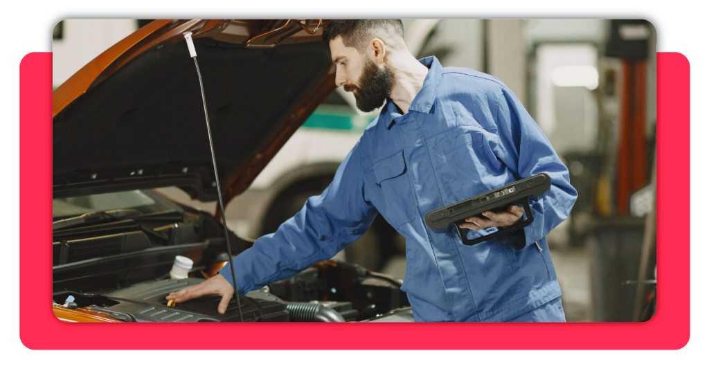 Un mecánico automotriz hace un diagnóstico completo en un vehículo, dentro del taller de reparaciones, gracias a un dispositivo de medición especial.