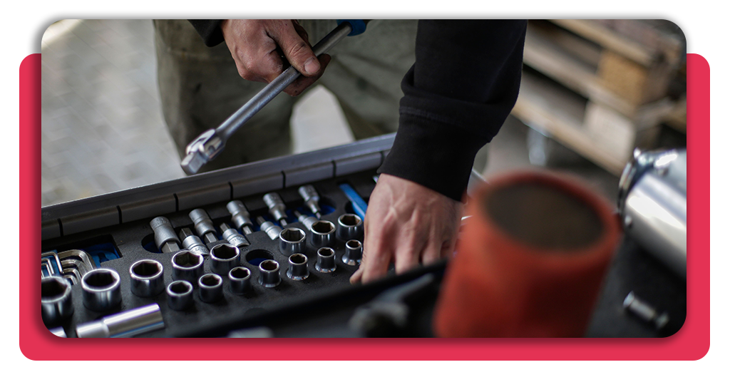 Curso gratis de mecánica automotriz con salarios de hasta 2.500 € 2 Un aprendiz de mecánica automotriz sosteniendo un ratchety revisando una caja de herramientas para extraer el dado adecuado para el trabajo