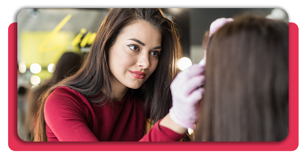 Una formadora especializada enseña técnicas de estética y maquillaje profesional sobre una modelo durante las clases prácticas del programa formativo.