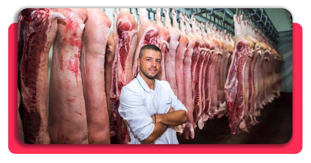 Curso de carnicería gratis: consigue tu certificado y empleo 3 Profesional de la industria alimentaria posando en un almacén de carne, preparado para aplicar las normativas de seguridad e higiene aprendidas.