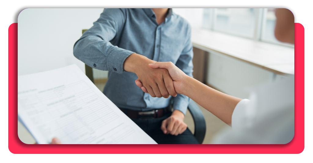 ¿Buscas empleo en Decathlon? Accede al curso de logística gratis 1 Dos personas estrechan sus manos luego de negociar las cláusulas de una contratación laboral. Uno de ellos sostiene el contrato en su mano.