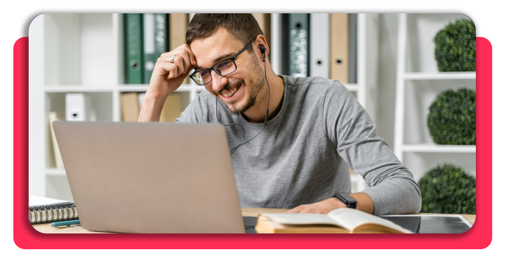 Chico sonriente estudiando concentrado frente a su ordenador portátil para completar con éxito su formación académica online y mejorar su currículum.