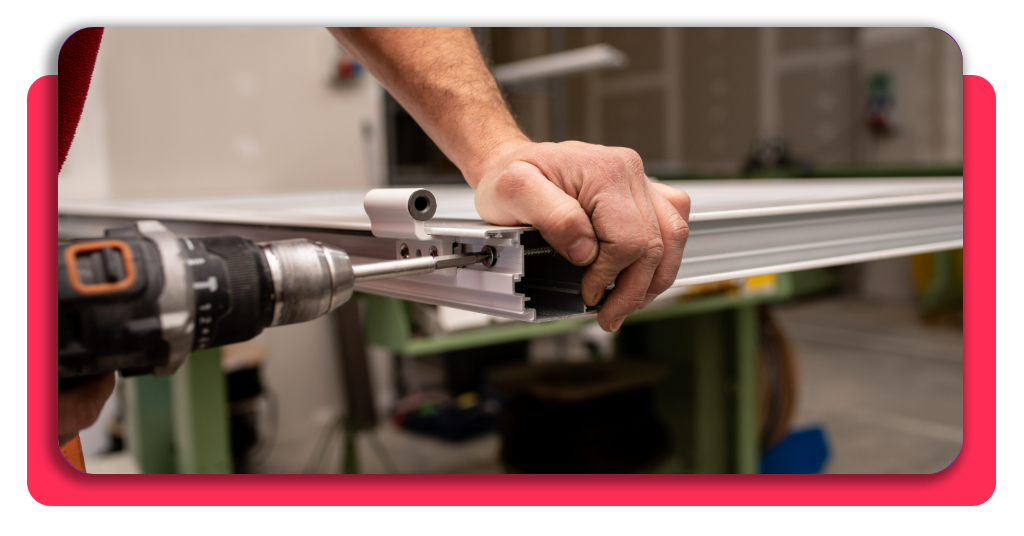 Deja la oficina: curso gratis de carpintería de aluminio 4 Un carpintero usando un taladro para colocar un tornillo en una ventana de metal